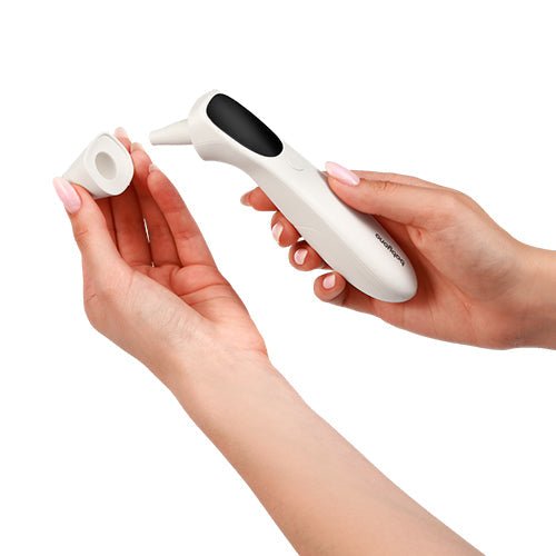 White non-contact infrared thermometer in hand, black sensor tip with reading screen