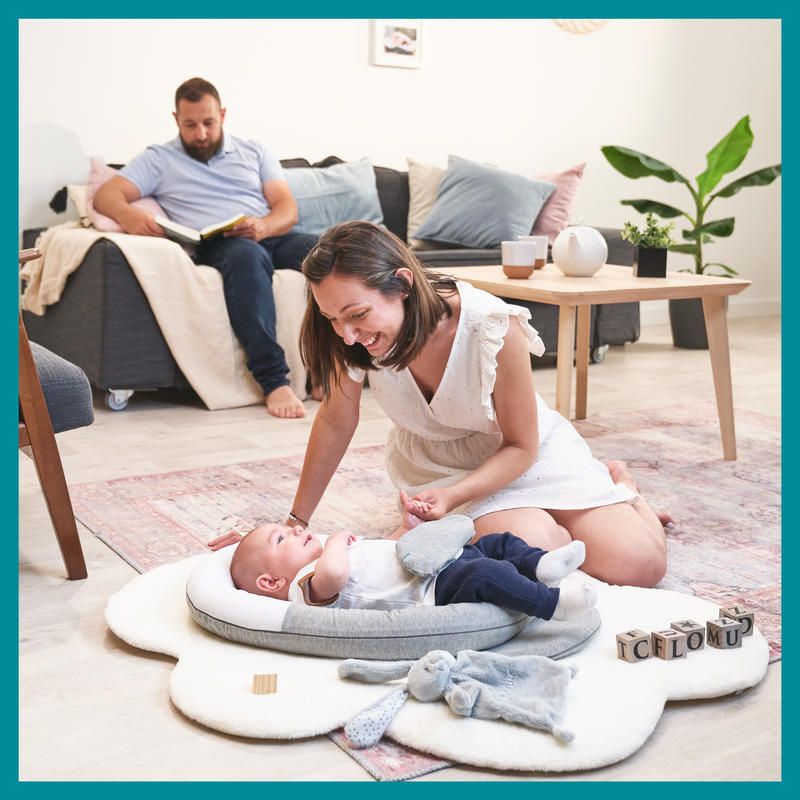 Anti-colic baby reducer pillow with gray and white cushions, supporting a sleeping infant