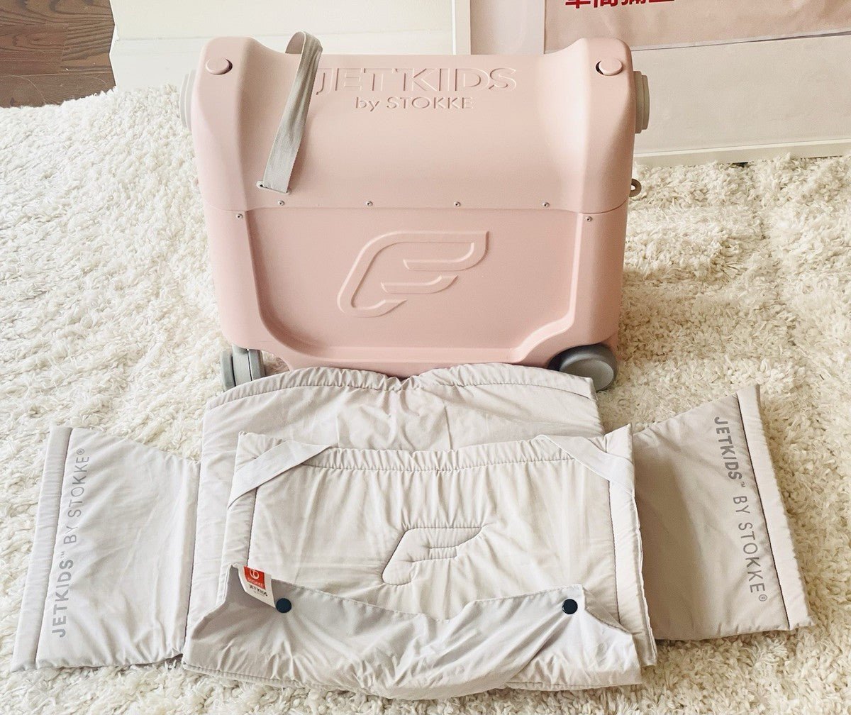 Light pink portable kids bedbox with bedding laid out on the top platform