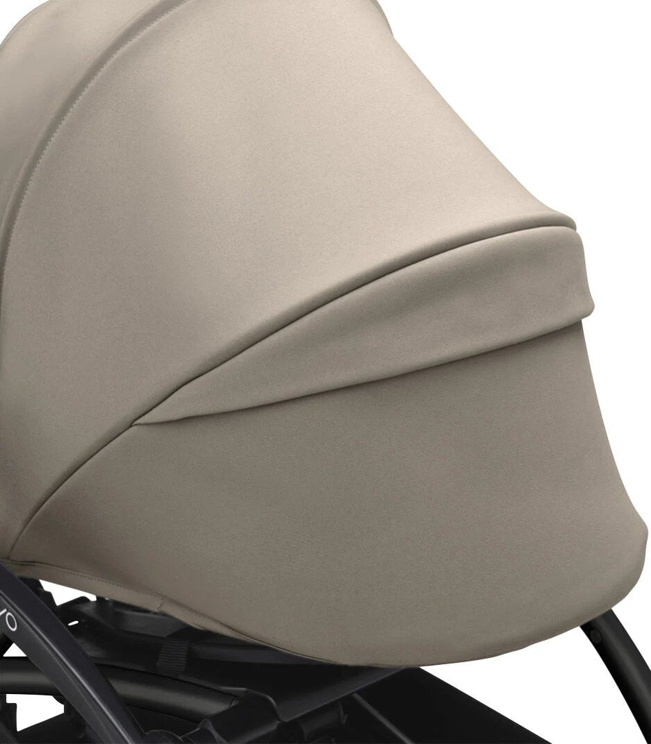 Gray stroller canopy with curved padded shell and dark bottom trim