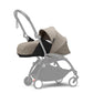 Newborn stroller pack with beige carrycot and seat, gray frame, front wheels