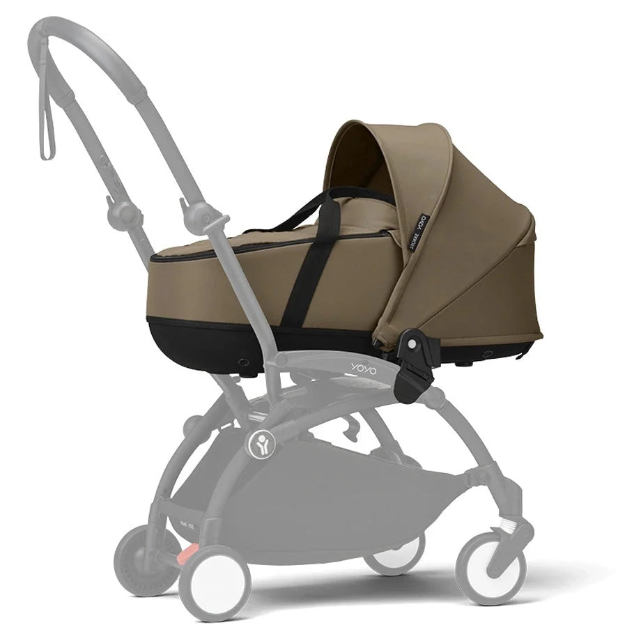 Newborn stroller in toffee tan with black frame, canopy, and storage basket