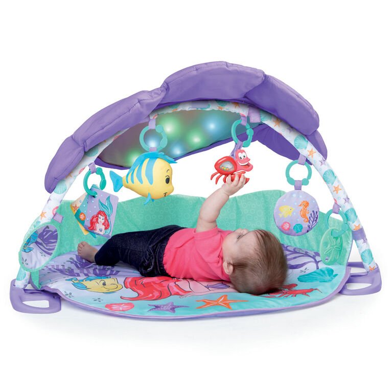 Baby activity gym with purple arch, ocean play mat, hanging toys, lights glowing