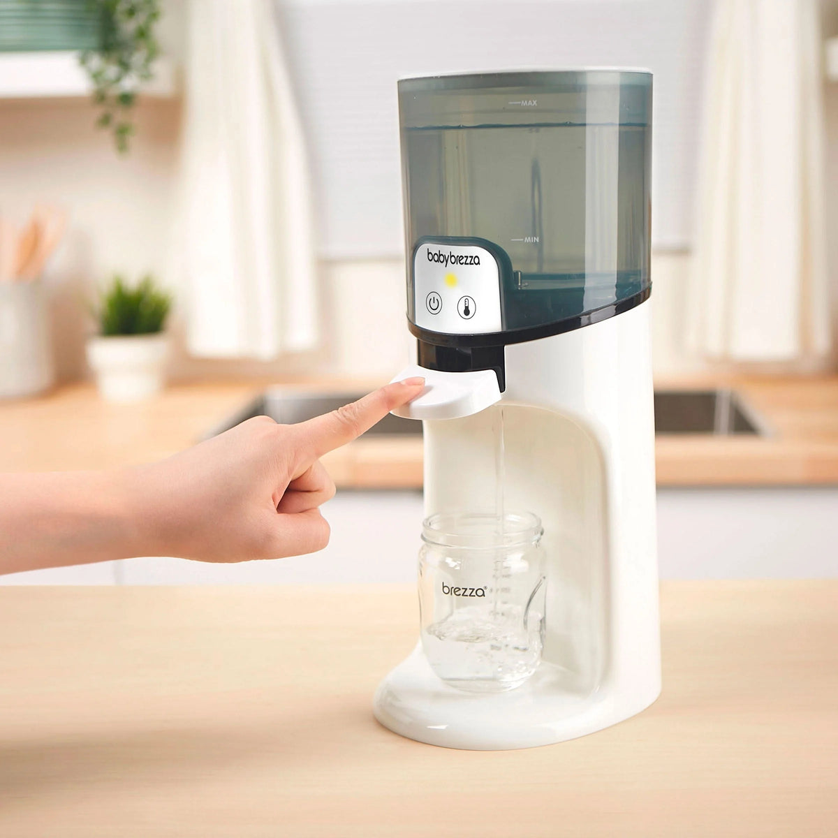 White warm water dispenser with dark lid; hand pressing front lever