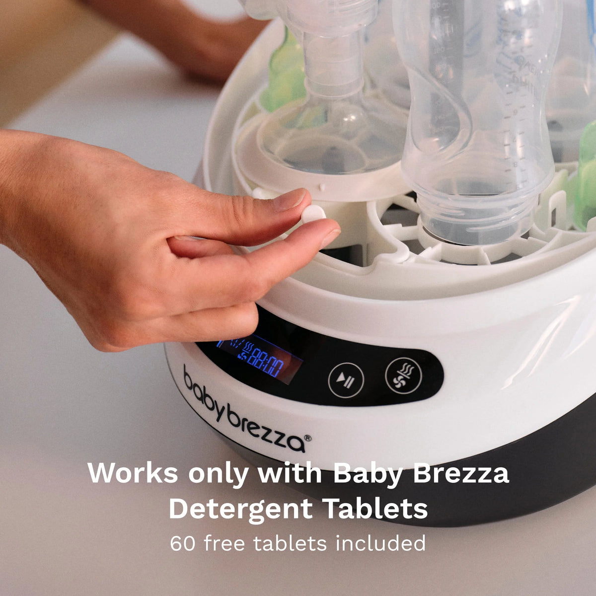 Bottle washer dryer with open top and hand touching the control buttons