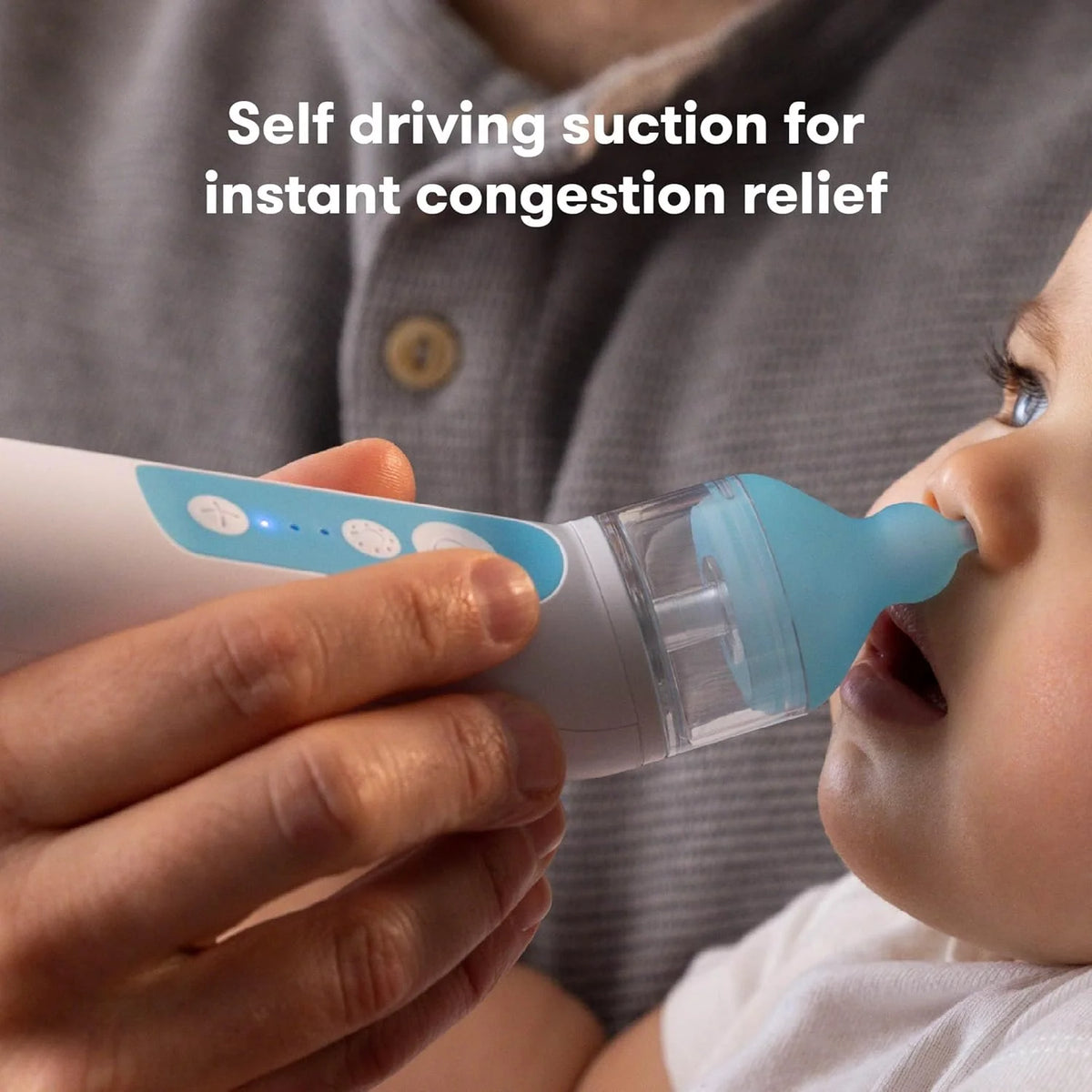 Electric nasal aspirator held near baby’s nose with clear chamber and light blue tip