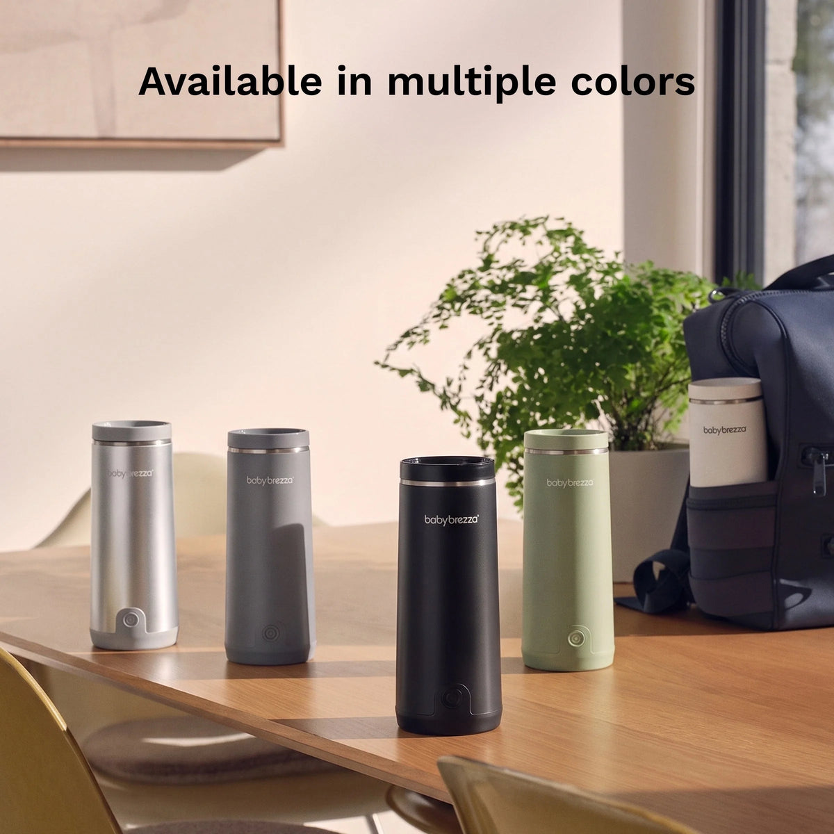 Portable bottle warmer, four compact cylinder colors lined up on a tabletop