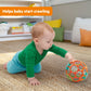 Colorful plastic rattle ball with multicolor rings, lying on carpet