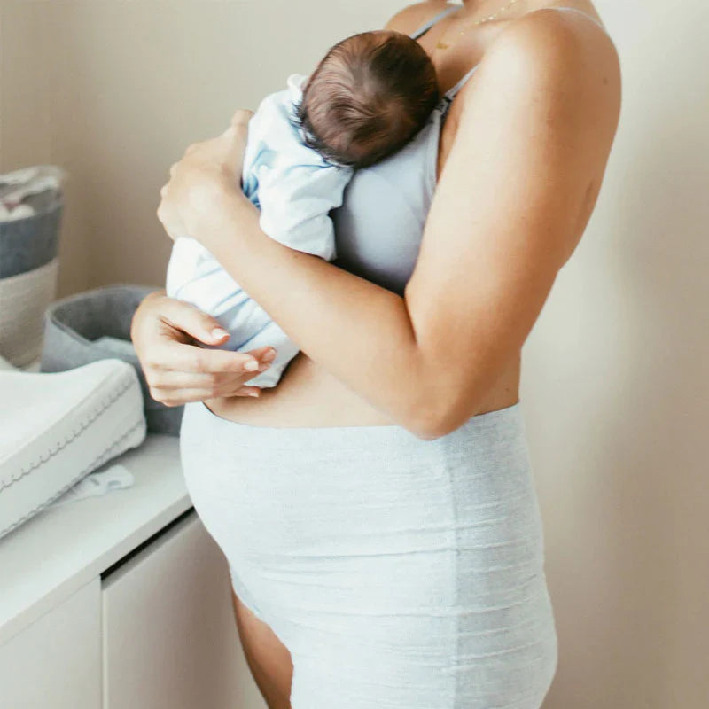 Gray heather postpartum boyshort underwear on wearer with newborn in arms