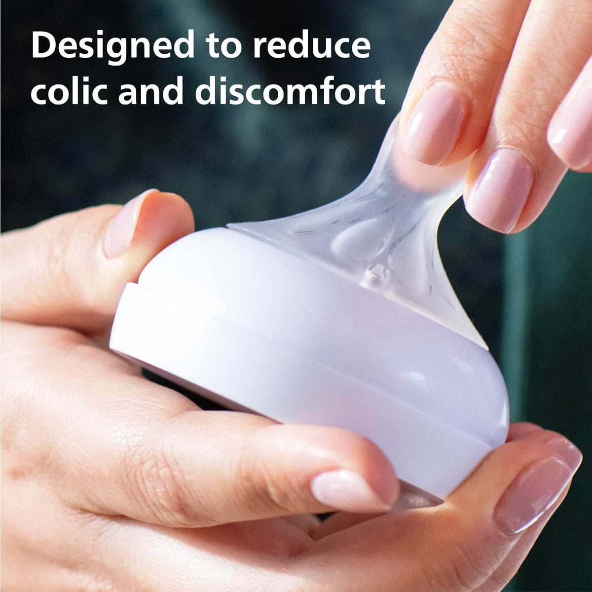 Silicone bottle nipple with soft, curved design held in hands