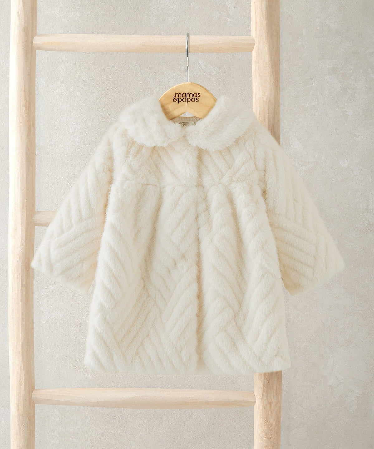 Cream faux fur coat with raised collar and chevron textured pattern, long sleeves