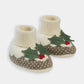 Pair of knit baby booties, cream cuffs, green tree motif with red berries, brown patterned sole