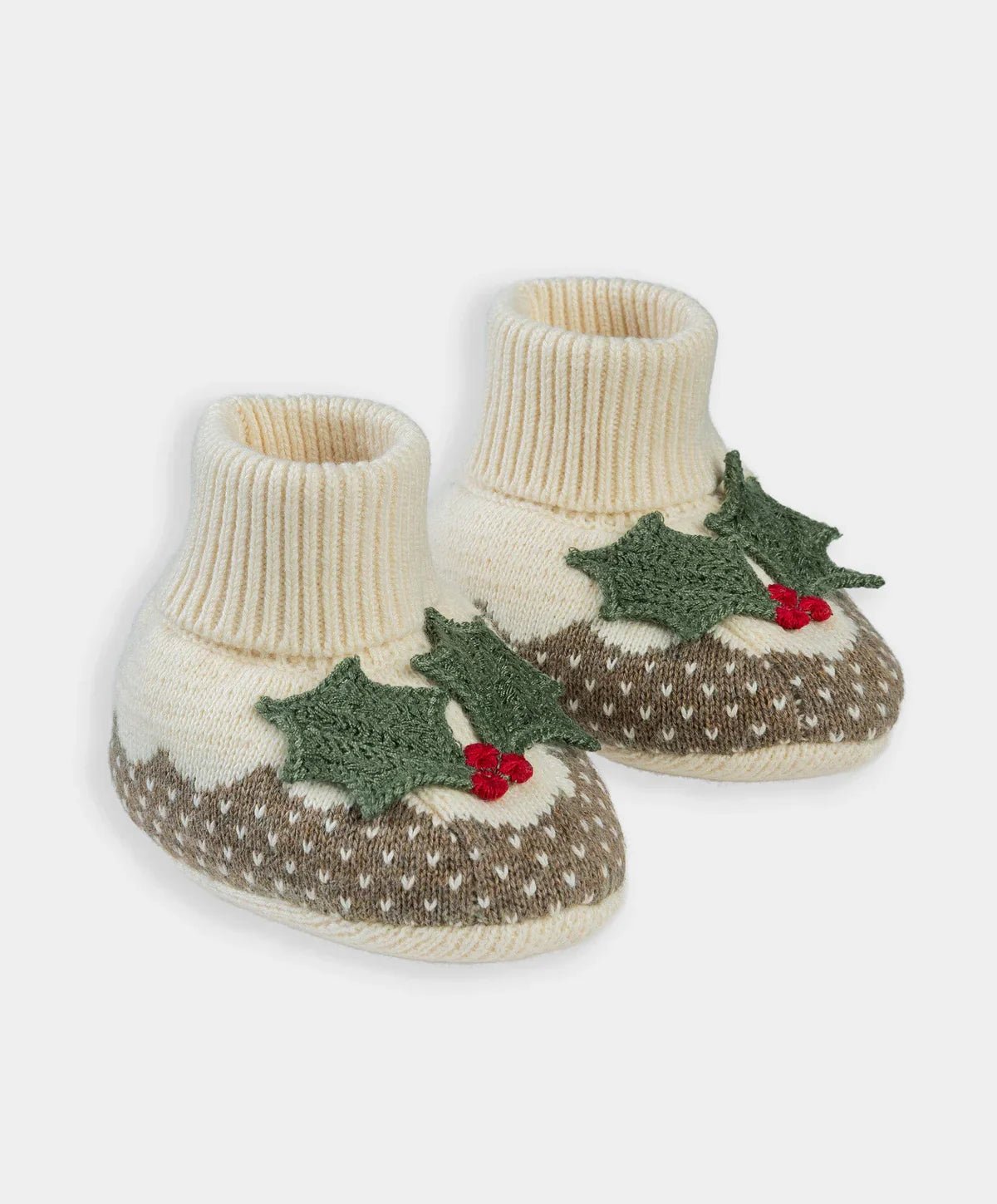 Pair of knit baby booties, cream cuffs, green tree motif with red berries, brown patterned sole