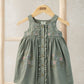 Floral pinafore dress in sage green with embroidered flowers and wooden button front.