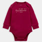 Red long-sleeve baby bodysuit with 'My first Christmas 2025' text and stars