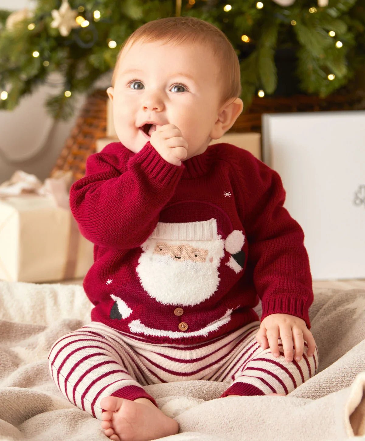Red Christmas jumper on baby with Santa knit motif, ribbed collar and cuffs