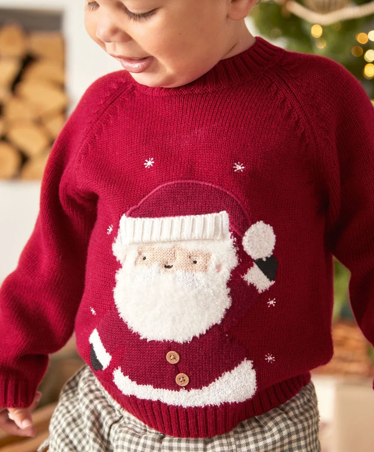 Red knit Christmas jumper close-up with Santa face and white striped hem graphic