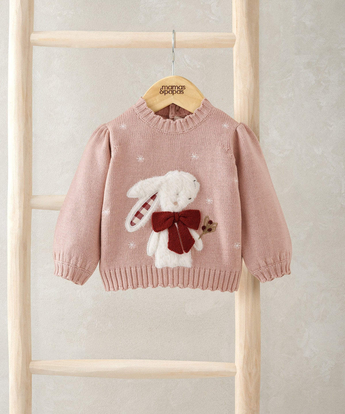 Light pink knit Christmas jumper with bunny appliqué and red bow at center, long sleeves