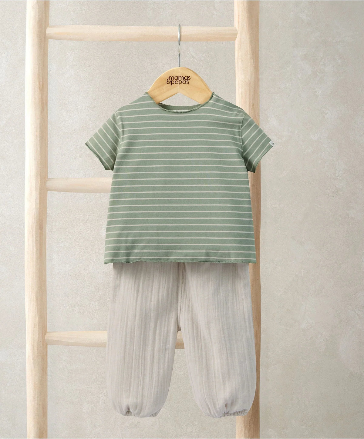 Outfit set on hanger: green-and-white striped tee and cream loose trousers