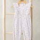 White baby dungarees with tiny scattered floral motifs and gathered waist