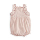 Light pink baby romper with scalloped trim, ruffled bodice, and gathered waist