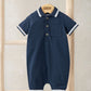 Navy jersey polo romper with button placket, chest pocket, and striped collar