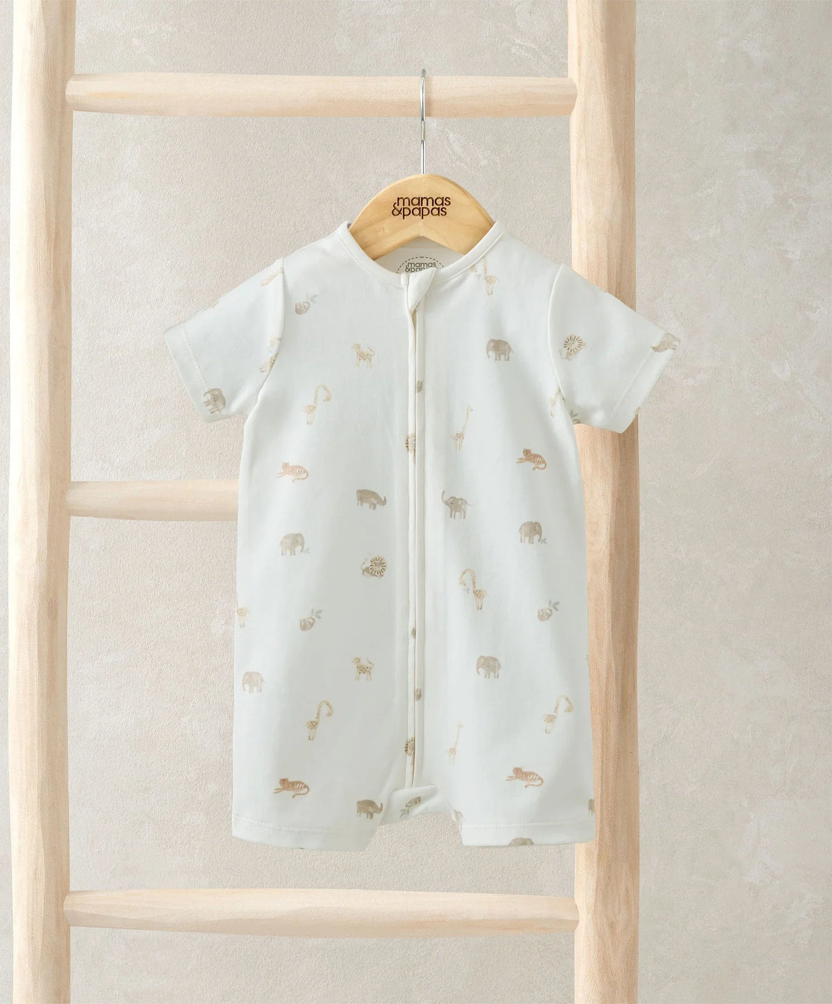 Shortie romper in light cream with all-over safari animal print, front zip, short sleeves.