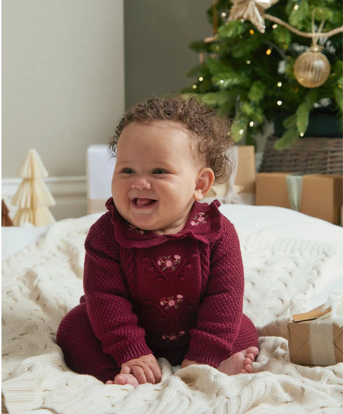 Burgundy soft knit romper on baby with long sleeves and front heart motifs