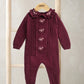 Burgundy soft knit romper with cable-knit long sleeves and footed legs