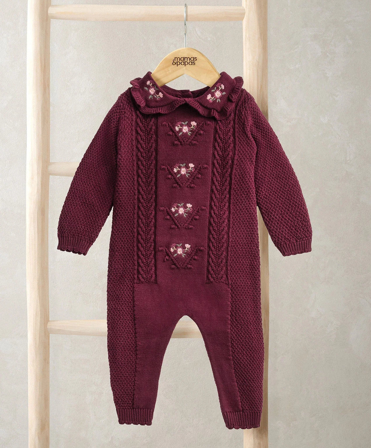 Burgundy soft knit romper with cable-knit long sleeves and footed legs