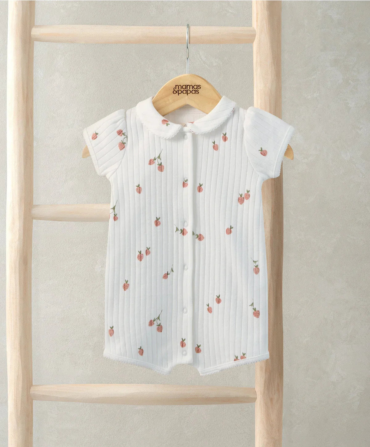 White strawberry-print romper with short sleeves and button front