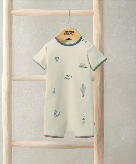 Cream shortie romper with teal trim and desert icons, hanging with Mama's & Papas tag