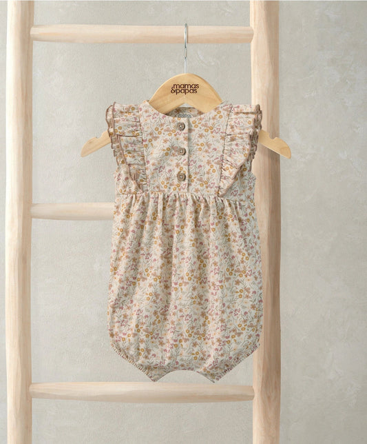 Ditsy floral shortie romper with ruffled cap sleeves and button front on cream fabric