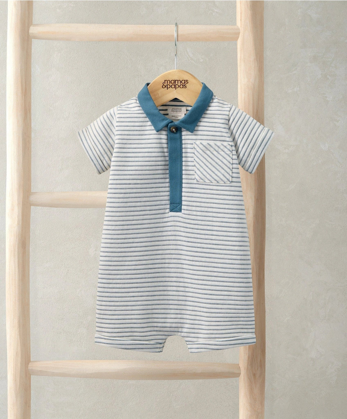 Striped polo romper with teal collar and button placket, short sleeves, hanging
