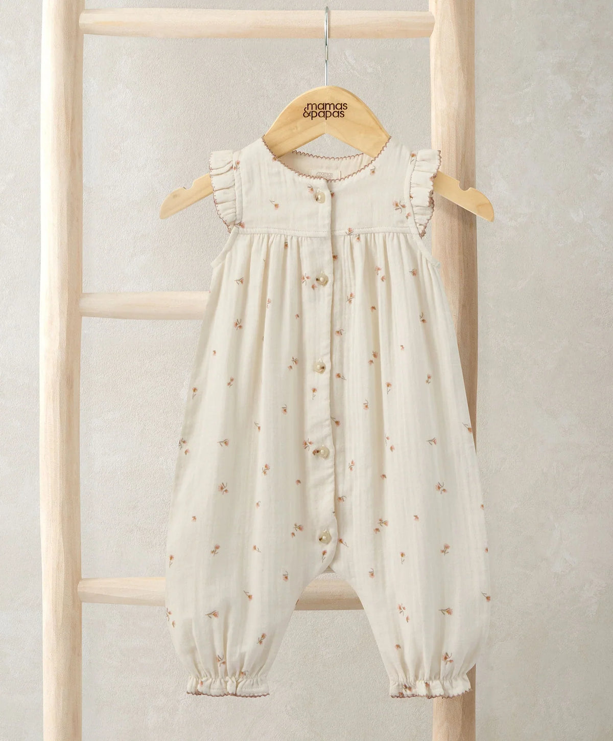 Cream frill-shoulder romper with tiny floral print, button front, gathered cuffs