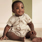 Ribbed short-sleeve baby romper in cream with small animal print and front buttons