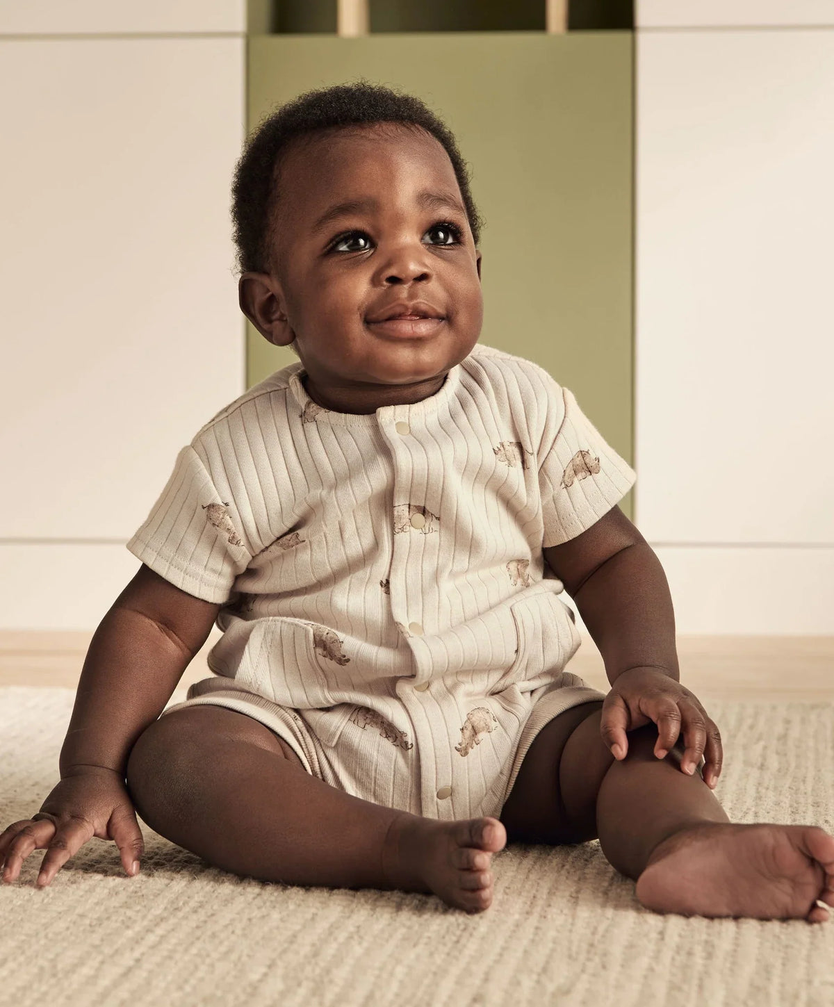 Ribbed short-sleeve baby romper in cream with small animal print and front buttons