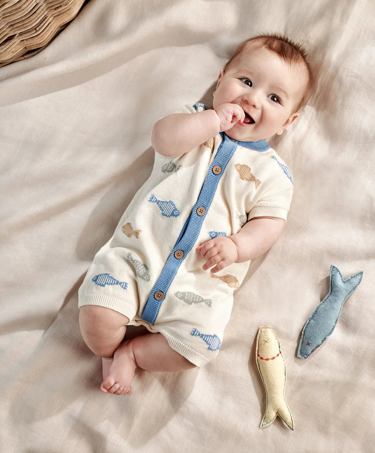 Cream knitted romper, blue button placket, fish prints, short sleeves, ribbed cuffs