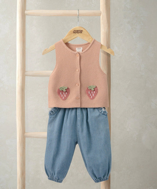 Pink knitted waistcoat with button front and strawberry appliques; denim trousers