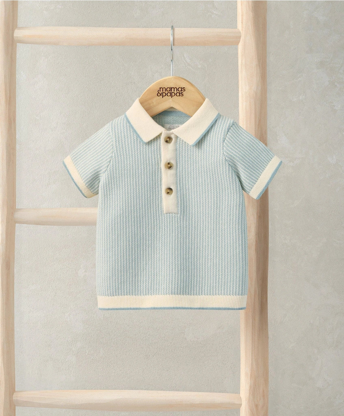 Light blue jacquard knitted polo shirt with cream collar and button placket