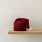 Red knitted baby hat with ribbed cuff and white pom-pom