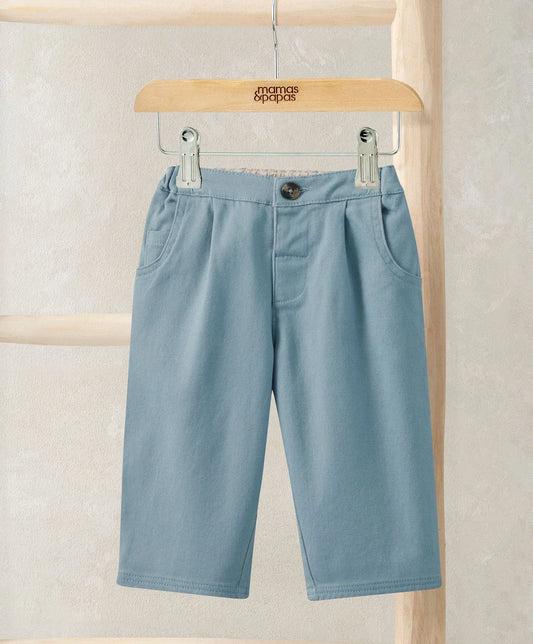 Light blue smart trousers with button waist and side pockets, hanging on a hanger