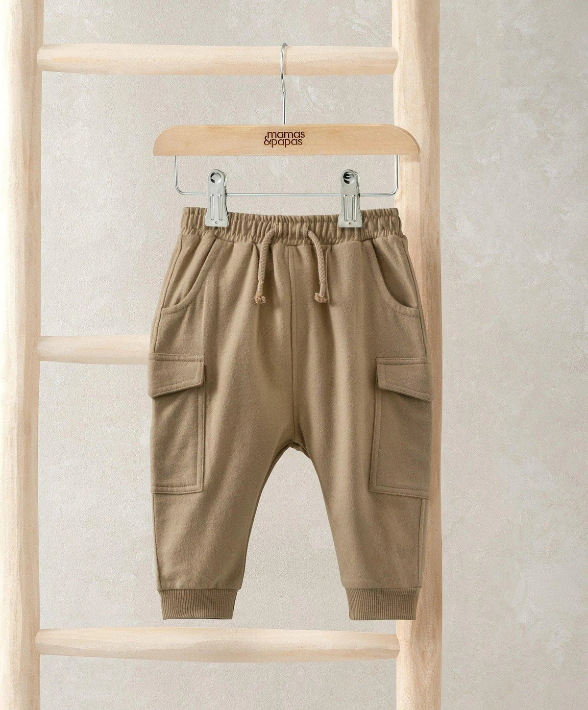 Tan utility joggers with drawstring waist and cargo pockets at the thighs