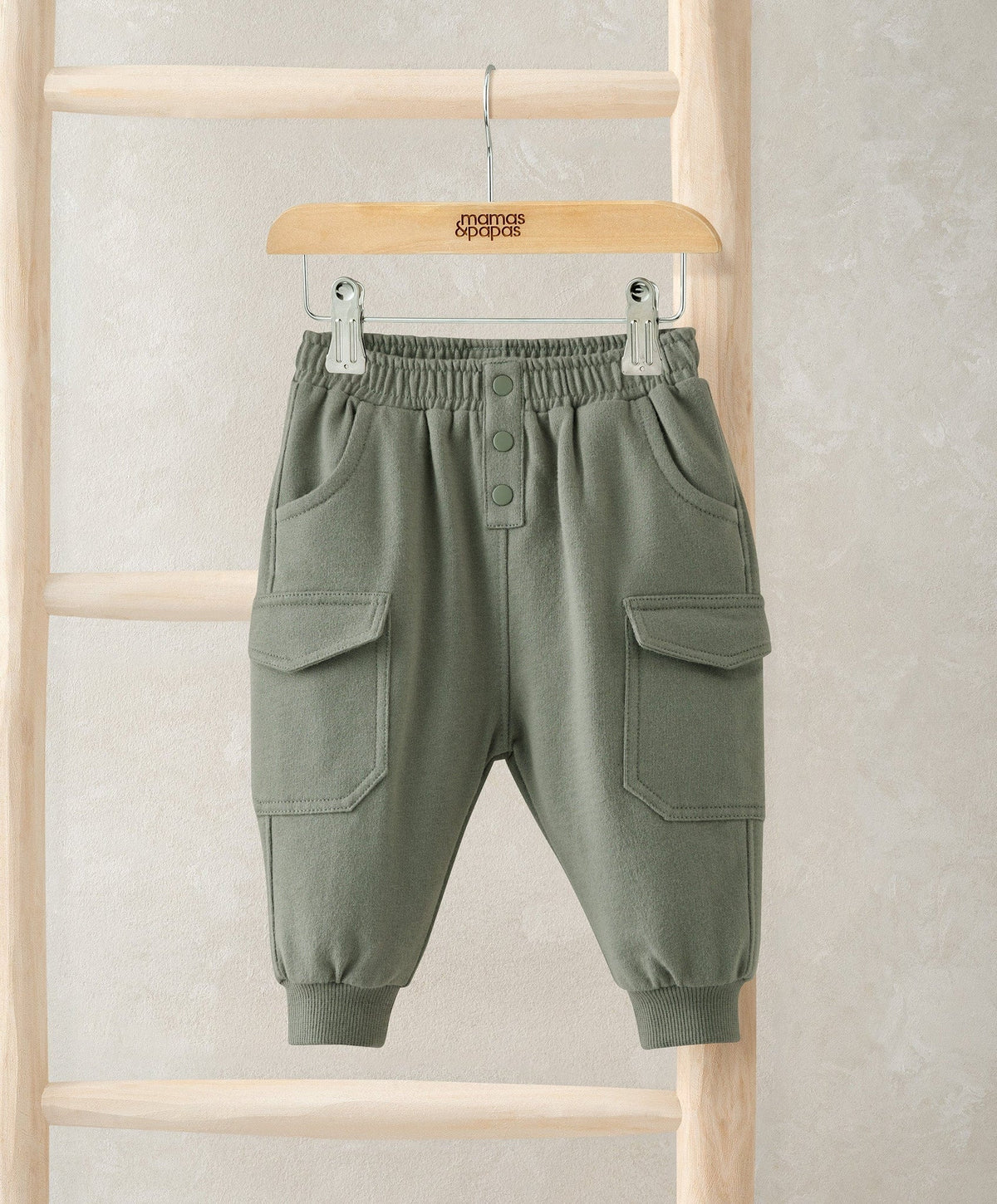 Dark green cargo jogger pants with elastic waistband, button front, side patch pockets