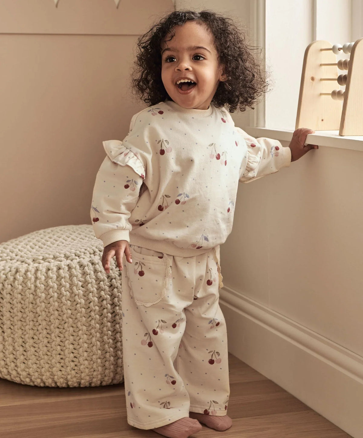 Cherry-print toddler joggers with elastic waist and patch pockets, off-white