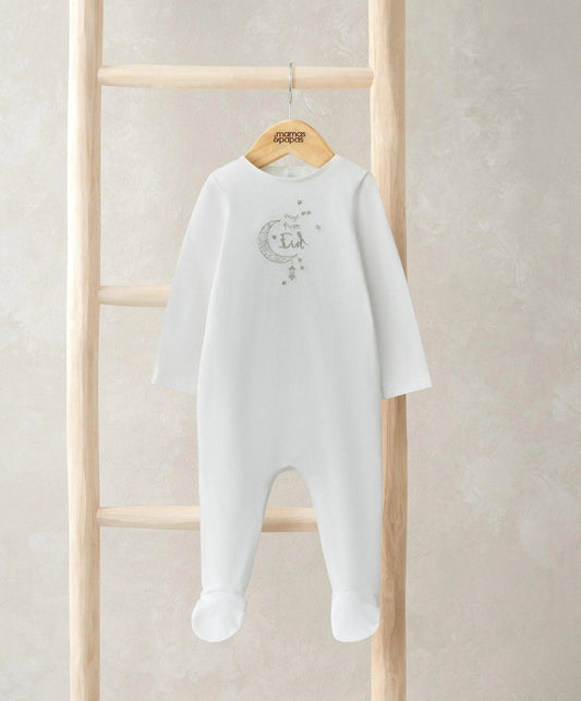 White footed all-in-one with long sleeves and embroidered Eid motif, hanging on hanger.