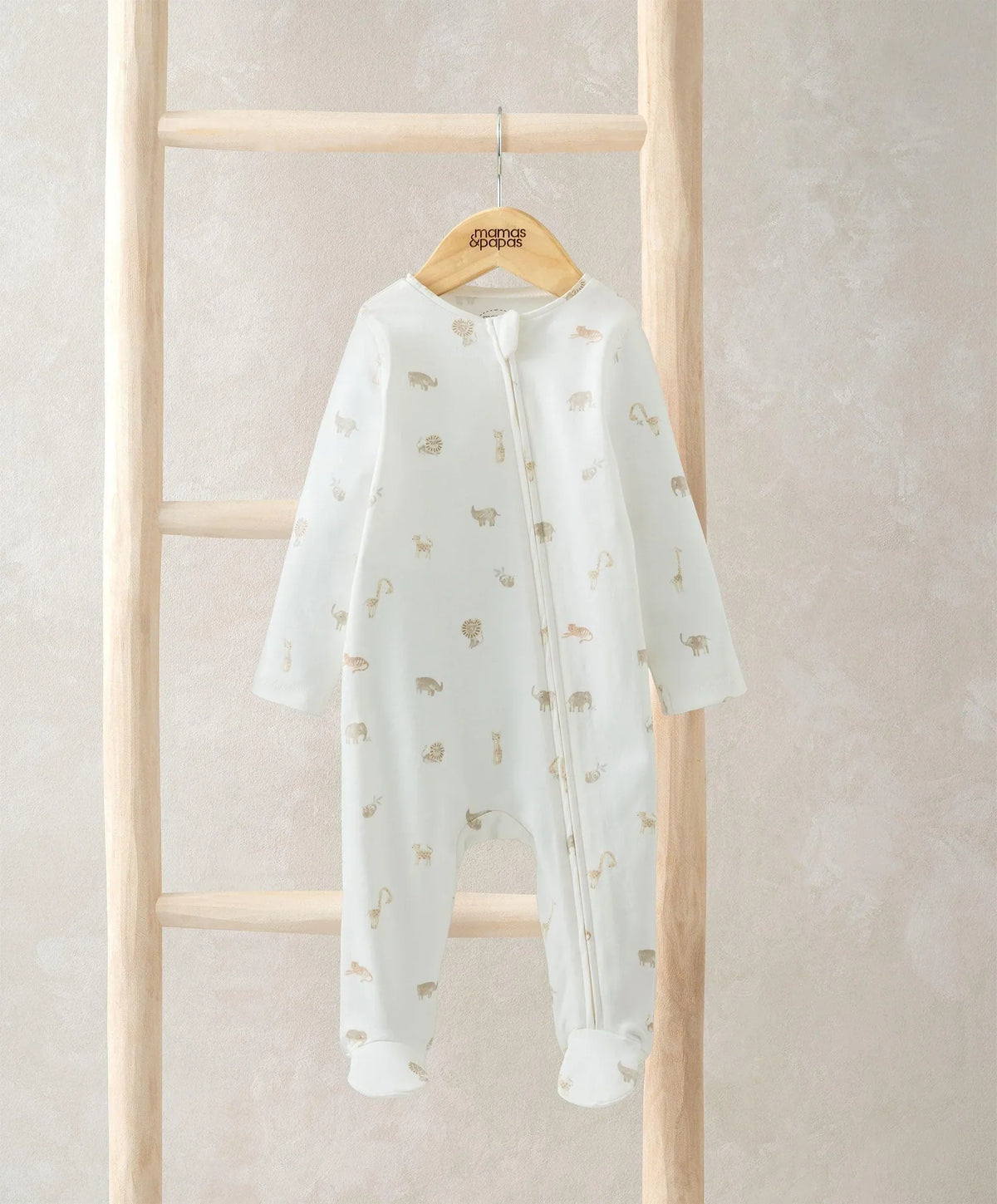 White safari-print footed all-in-one with zip front, long sleeves, on hanger