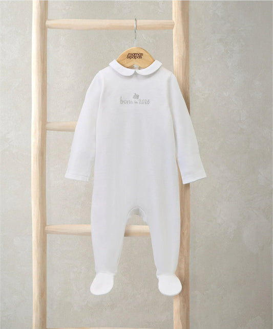 White embroidered baby romper on hanger, long sleeves, collar and chest text