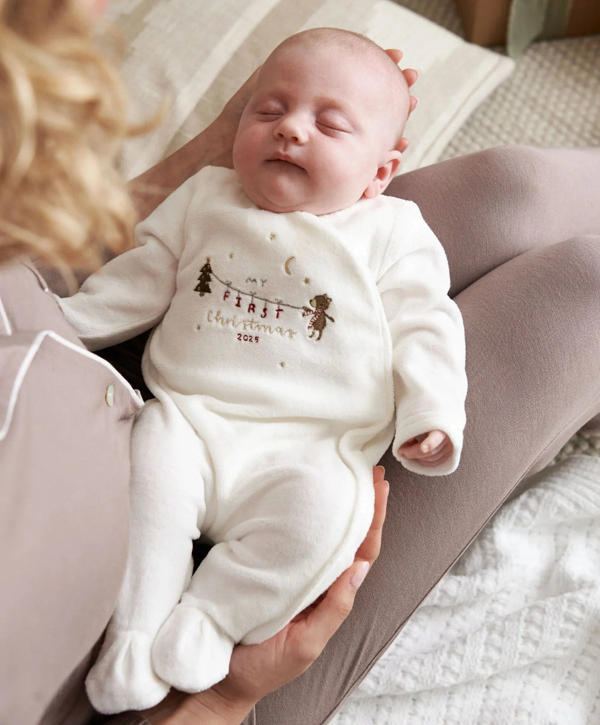 Velour all-in-one baby suit in white with long sleeves and Christmas graphic, worn by baby