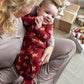 Baby all-in-one romper in dark red with gingerbread cookie print, long sleeves, footed